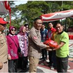 SIMBOLIS : Asisten Perekonomian dan Pembangunan, Leonard S Ampung ketika menyerahkan secara simbolis paket sembako, di halaman kantor gubernur, Jumat (24/3/2023). (foto:ist)