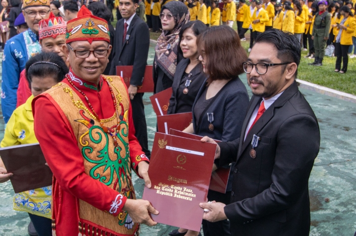 Rektor UPR, Prof. Dr. Ir. Salampak, MS saat menyerahkan penghargaan Satyalancana Karya Satya kepada Tenaga Pendidik, Dr. Kiki Kristanto, S.H., M.H (Foto : Humas Universitas Palangka Raya)