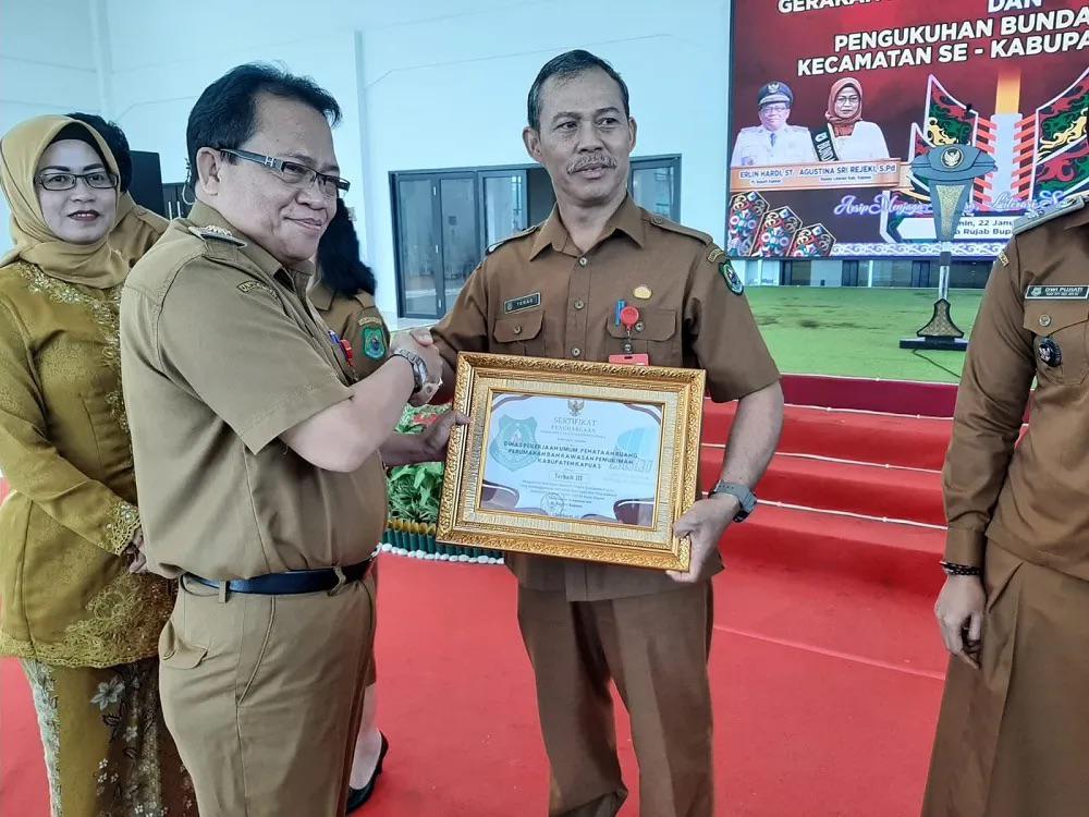 PENGHARGAAN : Kepala Dinas PUPR-PKP Kapuas Teras, saat menerima penghargaan dari Pj Bupati Kapuas Erlin Hardi, di Aula Rumah Jabatan Bupati Kapuas, Senin (22/1/2024). (foto:ist)