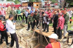 PELETAKKAN BATU PERTAMA : Pj Bupati Barsel, Deddy saat melakukan peletakan batu pertama pembangunan Rumah Betang DAD.