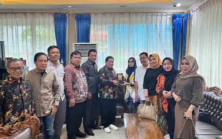 Komisi II DPRD Kabupaten Kapuas, melakukan foto bersama dan menyerahkan cendramata dalam kunker ke DPRD Kota Banjarmasin (Foto : Ist)